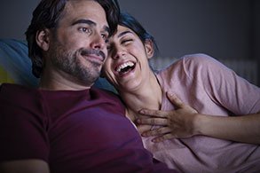 Couple sur canapé qui rit