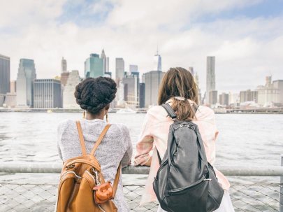 Deux femmes regardant Manhattan depuis un bateau, avec des gratte-ciel en arrière-plan.