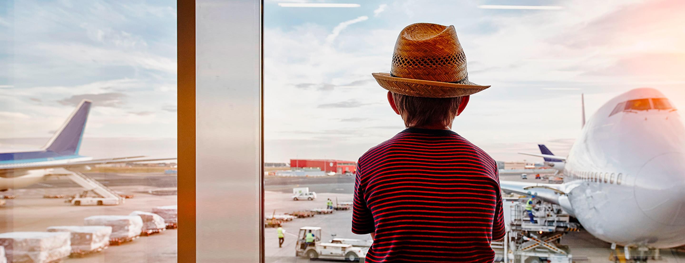 Enfant assis dans un aéroport qui regarde un avion