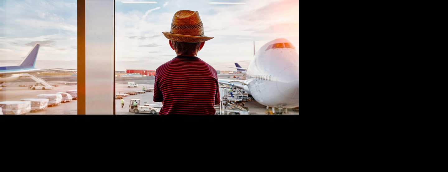 Enfant assis dans un aéroport qui regarde un avion