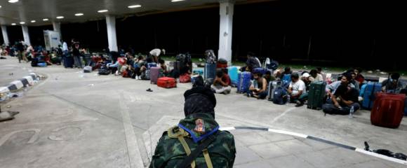 Un soldat thaïlandais surveille des personnes qui ont traversé la frontière depuis la Birmanie, en attente d'être contrôlées et interrogées par les autorités  dans le district de Mae Sot, dans la province de Tak, le 23 octobre 2025 Un soldat thaïlandais surveille des personnes qui ont traversé la frontière depuis la Birmanie, en attente d'être contrôlées et interrogées par les autorités  dans le district de Mae Sot, dans la province de Tak, le 23 octobre 2025