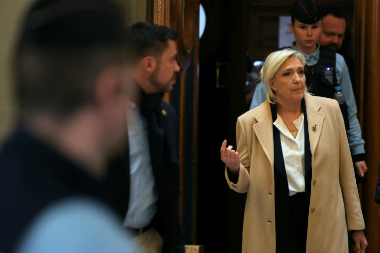 Marine Le Pen (c), présidente du groupe parlementaire Rassemblement national, quitte le palais de justice lors d'une suspension d'audience, le 11 février 2026 à Paris