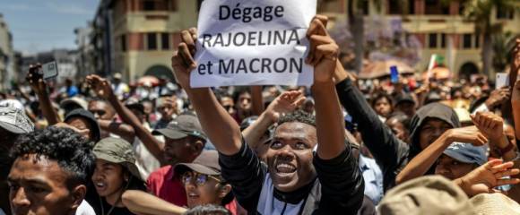 Un manifestant brandit une pancarte critique du président malgache et du président français lors d'un rassemblement à Antananarivo le 14 octobre 2025 Un manifestant brandit une pancarte critique du président malgache et du président français lors d'un rassemblement à Antananarivo le 14 octobre 2025