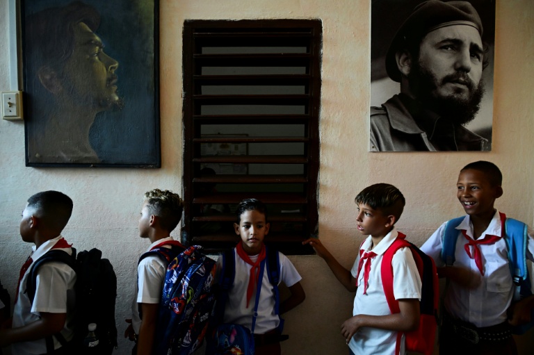 Des élèves sont en rang sous les portraits des dirigeants de la révolution cubain, Fidel Castro et l'Argentin Che Guevara, le jours de la rentrée des classes dans une école de La Havane, le 1er septembre 2026