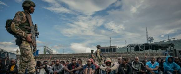 Un soldat du M23 surveille des combattants "neutralisés" du FDLR et d'autres groupes armés dans un stade de Goma, en République démocratique du Congo, le 10 mai 2025 Un soldat du M23 surveille des combattants "neutralisés" du FDLR et d'autres groupes armés dans un stade de Goma, en République démocratique du Congo, le 10 mai 2025