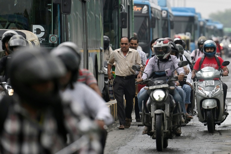 Des piétons au milieu de la circulation sur un pont à New Delhi, le 8 juillet 2026 en Inde