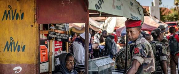 Au lendemain de la prise de pouvoir, un soldat de l'unité Capsat discute avec une vendeuse près de sa base militaire à Antananarivo, le 15 octobre 2025 Au lendemain de la prise de pouvoir, un soldat de l'unité Capsat discute avec une vendeuse près de sa base militaire à Antananarivo, le 15 octobre 2025