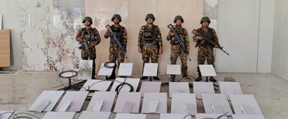 Des militaires de la junte birmane à côté d'appareils Starlink saisis au KK Park - photo prise le 20 octobre 2025 et publiée le 22 octobre par l'armée birmane Des militaires de la junte birmane à côté d'appareils Starlink saisis au KK Park - photo prise le 20 octobre 2025 et publiée le 22 octobre par l'armée birmane