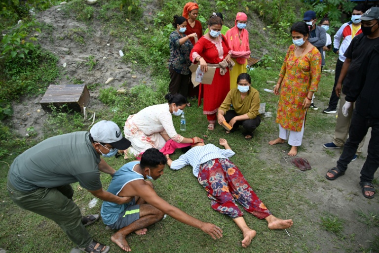 Des proches réconfortent Monac Khadka (4e à partir de la gauche) et Krishna Khadka (2e à partir de la gauche) lors de la crémation de leur fils, Ayush Khadka, à la suite de crues soudaines, dans le district de Chitwan, au Népal, le 31 août 2026