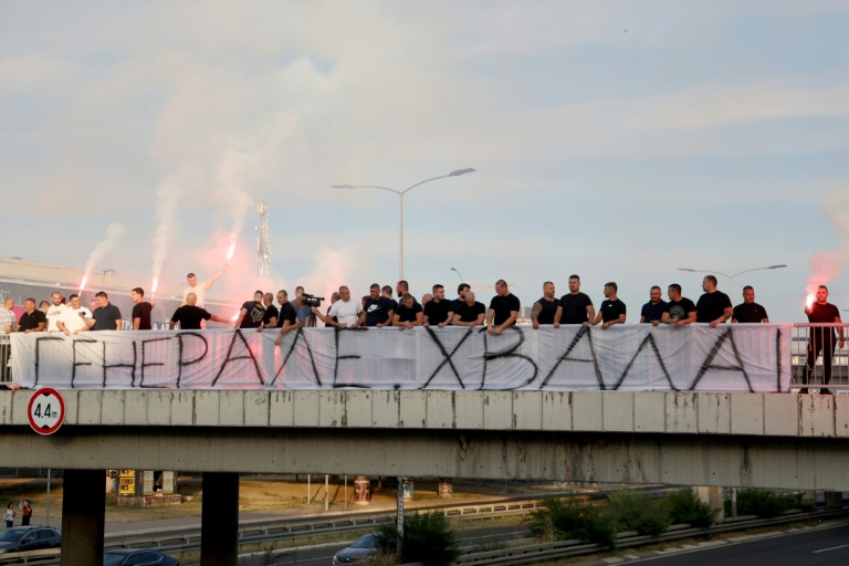 Des personnes rassemblées sur une passerelle d'autoroute tiennent une banderole "Merci, Général", avant le passage du convoi transportant la dépouille du criminel de guerre serbe de Bosnie Ratko Mladić à Belgrade, en Serbie, le 3 septembre 2026