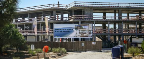 Un panneau d'affichage fait la promotion d'un "complexe de plage et de golf" devant un bâtiment en construction à Comporta,le 29 septembre 2025 au Portugal Un panneau d'affichage fait la promotion d'un "complexe de plage et de golf" devant un bâtiment en construction à Comporta,le 29 septembre 2025 au Portugal