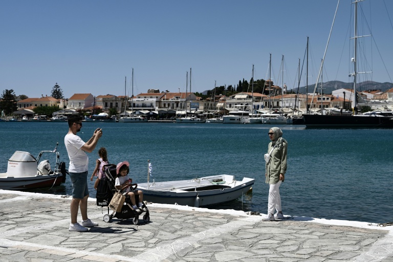 Une famille venue de Turquie prend des photos dans le village de Pythagorion, sur l’île de Samos, le 24 juillet 2026