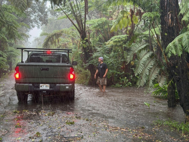 Un habitant s'arrête sur une route rurale alors qu'elle est inondée à Volcano Village, sur l'île d'Hawaï, le 15 août 2026