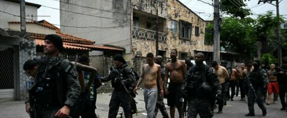 Des policiers escortent des criminels présumés arrêtés lors d'une opération dans la favela de Vila Cruzeiro, dans le complexe de Penha, à Rio de Janeiro, le 28 octobre 2025 au Brésil Des policiers escortent des criminels présumés arrêtés lors d'une opération dans la favela de Vila Cruzeiro, dans le complexe de Penha, à Rio de Janeiro, le 28 octobre 2025 au Brésil