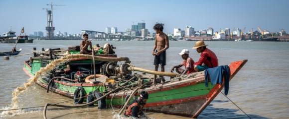 Des hommes récupèrent un navire coulé dans le fleuve Yangon, le 20 février 2024 à Rangoun, en Birmanie