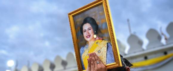Une femme endeuillée tient un portrait de la reine mère Sirikit de Thaïlande au passage du cortège funéraire, le 26 octobre 2025 à Bangkok Une femme endeuillée tient un portrait de la reine mère Sirikit de Thaïlande au passage du cortège funéraire, le 26 octobre 2025 à Bangkok