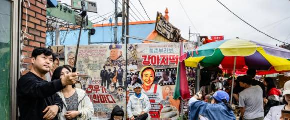 Des visiteurs prennent des photos et des selfies sur un marché de l'île de Gyodong, le 7 octobre 2025 en Corée du Sud Des visiteurs prennent des photos et des selfies sur un marché de l'île de Gyodong, le 7 octobre 2025 en Corée du Sud