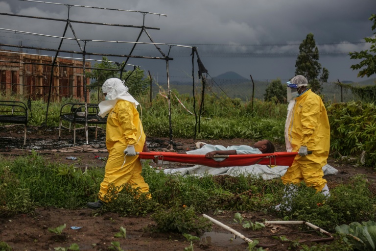 Des membres du personnel médical portant des équipements de protection individuelle transportent un patient sur une civière à l’hôpital de Rwampara, en République démocratique du Congo, le 21 mai 2026
