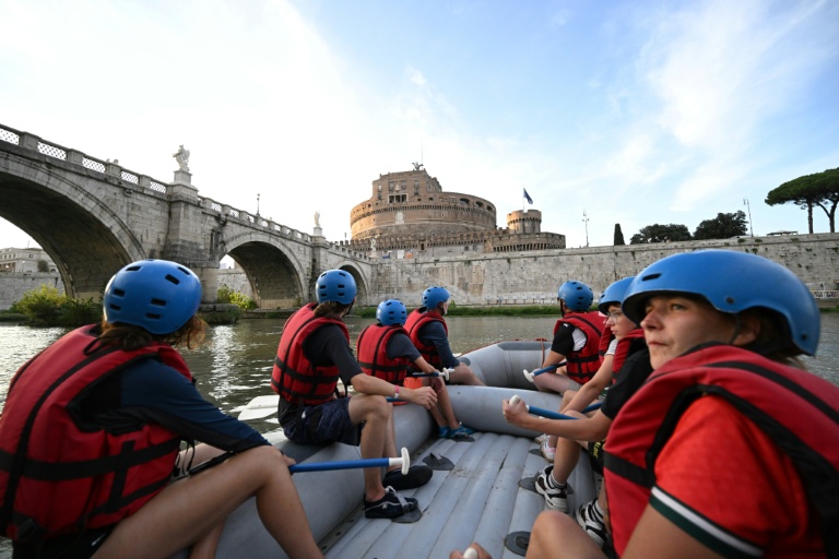 Des personnes naviguent en canot pneumatique sur le Tibre, passant devant le château Saint-Ange, sur un tronçon du fleuve situé entièrement dans la zone urbaine du centre de Rome, le 14 août 2026.