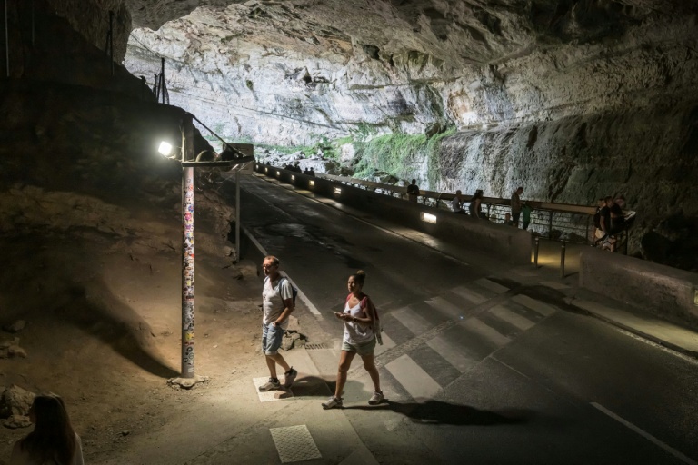 Des personnes marchent dans la grotte du Mas d'Azil, en Ariège, le 5 août 2026