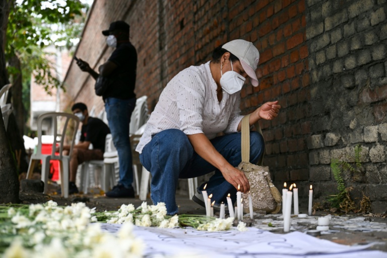 Une bénévole allume un cierge dans un mémorial improvisé dédié aux victimes du séisme, près de la morgue de Palmira, en Colombie, le 14 août 2026