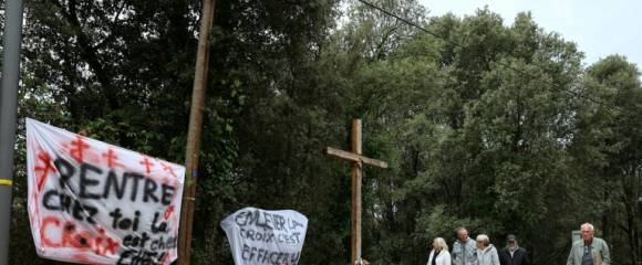Des banderoles à côté d'une croix en bois objet de polémiques à l'entrée du village de Quasquara, le 14 octobre 2025 en Corse-du-Sud Des banderoles à côté d'une croix en bois objet de polémiques à l'entrée du village de Quasquara, le 14 octobre 2025 en Corse-du-Sud