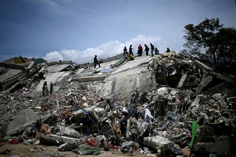 Des secouristes et des pompiers dans les décombres d'immeubles effondrés lors du double séisme du 24 jui, à Catia La Mar, dans l'Etat de La Guaira, le 8 juillet 2026 au Venezuela