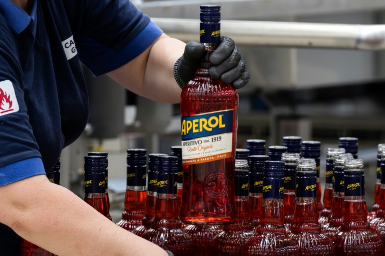 Un ouvrier de l'usine phare du groupe Campari à Novi Ligure, dans le nord-ouest de l'Italie, tient une bouteille d'Aperol, le 21 juillet 2026