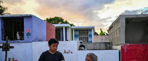 Un jeune accompagné de sa grand-mère se prépare à nettoyer les restes d'un proche avant les célébrations du Jour des Morts au cimetière de Pomuch, dans l'État de Campeche, au Mexique, le 18 octobre 202 Un jeune accompagné de sa grand-mère se prépare à nettoyer les restes d'un proche avant les célébrations du Jour des Morts au cimetière de Pomuch, dans l'État de Campeche, au Mexique, le 18 octobre 202