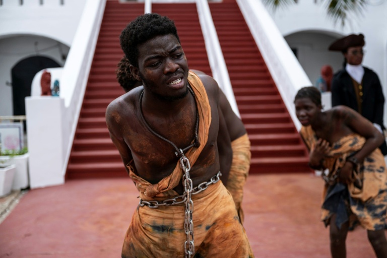 Des étudiants interprètent une reconstitution de la traite des esclaves au département des Arts du théâtre de l’Université du Ghana, au château de Christiansborg, ancien cachot d’esclaves, à Accra, le 19 juin 2026