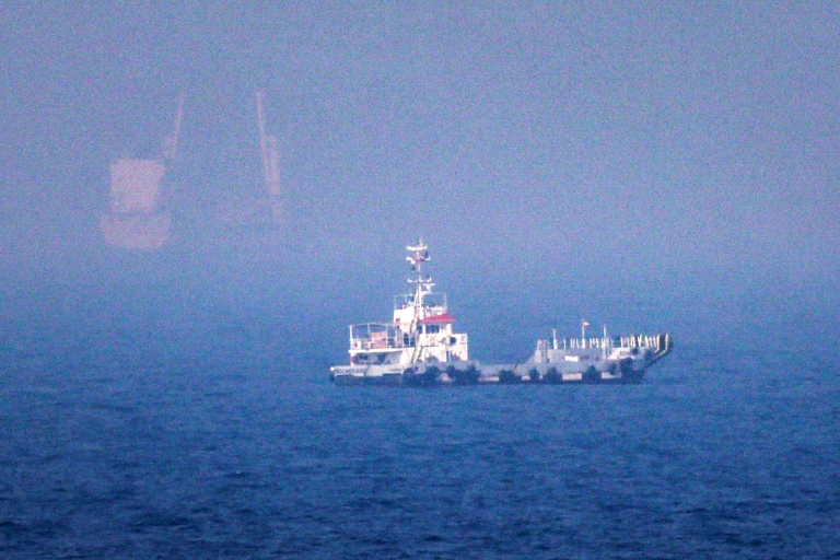 Des navires naviguent près du détroit d'Ormuz, au large de la côte orientale des Émirats arabes unis, à Khor Fakkan, le 13 juillet 2026